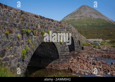 Th Old Bridge of Sligachan, that spans the rocky water bed of River Sligachan on the Isle of Skye, Sligachan, Scotland, United Kingdom on a cloudless