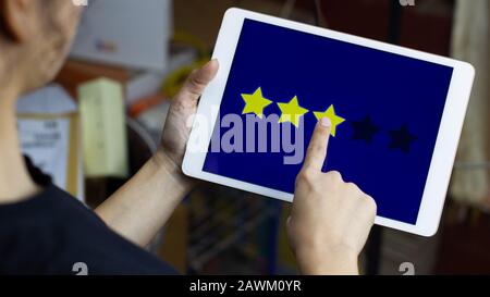 Conceptual the customer responded to the survey. The client give a three star icon on screen. Service experience and satisfaction concept. Stock Photo