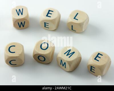 Welcome written in wooden cubes on a white desk Stock Photo