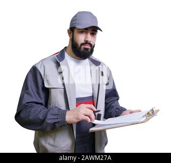 Concentrated young technician wearing overall standing and taking some notes Stock Photo
