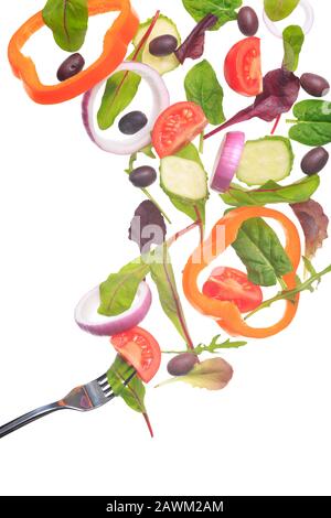Green salad flying to the fork. Fantasy salad. Isolated on white. Vertical Stock Photo