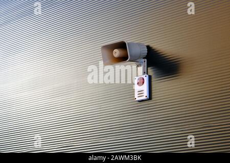 Megaphone for signaling in case of fire on the wall of a warehouse building. Fire safety Stock Photo