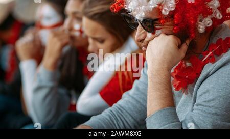 English fans upset about defeat of football team, watching a match live at stadium. Unhappy and depressed football fan after losing the championship m Stock Photo