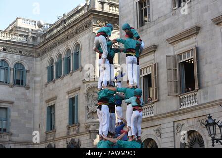 Castellers form a castel, a human tower, seen during the Santa Elulalia festival in Barcelona.These human towers are built traditionally during the festivals within Catalonia, several teams gather with an attempt to build and dismantle a human tower structure. Stock Photo