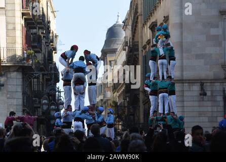 Castellers form castels, human towers, seen during the Santa Elulalia festival in Barcelona.These human towers are built traditionally during the festivals within Catalonia, several teams gather with an attempt to build and dismantle a human tower structure. Stock Photo