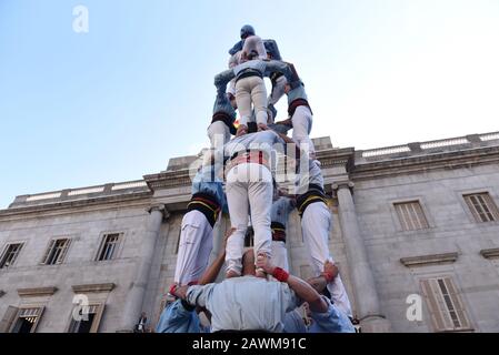 Castellers form a castel, a human tower, seen during the Santa Elulalia festival in Barcelona.These human towers are built traditionally during the festivals within Catalonia, several teams gather with an attempt to build and dismantle a human tower structure. Stock Photo