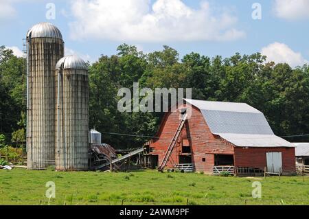 Old Red Barn and Grain Silos on a Working Farm in the Country Stock Photo