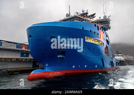 AHTS anchor handling multi-purpose offshore support vessel Horizon Arctic at Skoltegrunnskaien quay, Bergen, Norway. A dark, rainy and foggy winter da Stock Photo