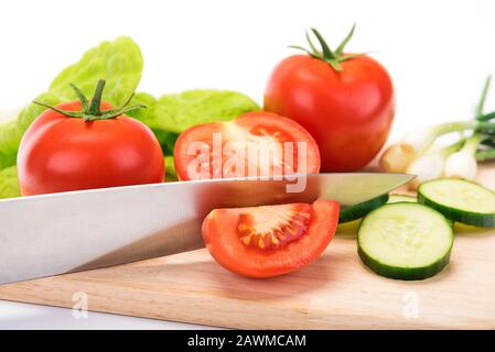 Concept of preparing a healthy salad - fresh and organic vegetables on a cutting board with a knife Stock Photo