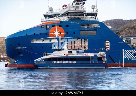 Hight speed passenger catamaram Rygertroll passing AHTS anchor handling multi-purpose offshore support vessel Horizon Arctic at Skoltegrunnskaien quay Stock Photo