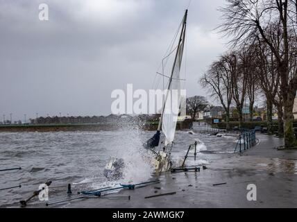 Yacht washed ashore and grounded during Storm Ciara at Cardwell Bay, Gourock, UK with  H M Coastguard in attendance Stock Photo