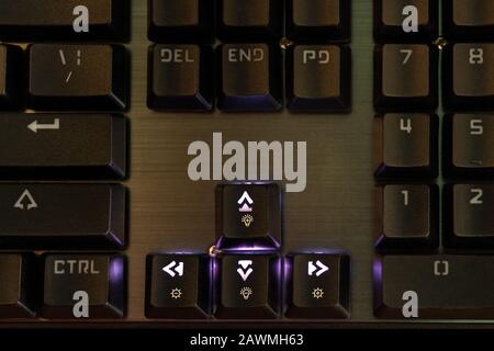 arrow keys and brightness - contrast adjustment with backlight on the black keyboard Stock Photo