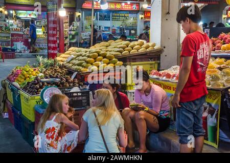 PATTAYA, THAILAND – DEC. 21, 2018: Street vendor selling durians, bananas, mangoes, tangerines, pineapples and tropical fruits on street of Pattaya. Stock Photo