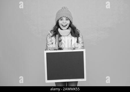 Fresh information. Schedule and working hours. Open hours. Winter entertainment and activities. Happy hours. Promotion concept. Smiling girl wear winter outfit show blank chalkboard copy space. Stock Photo