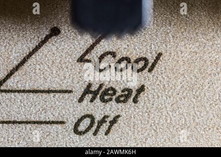 Macro close up photograph of vintage thermostat heat and air conditioning control switch. Stock Photo