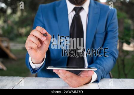 Conceptual hand writing showing Life Insurance. Concept meaning pays out a sum of money on the death of the insured demonstrating Businessman pointing Stock Photo