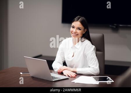 Beautiful businessman using laptop at table in conference room. Stock Photo