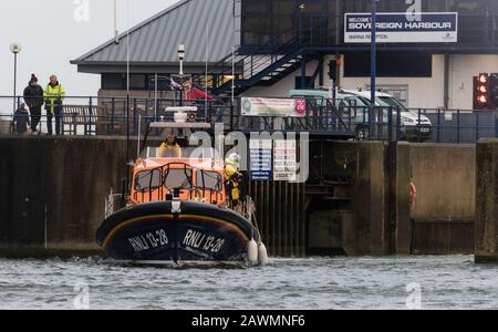 Eastbourne, East Sussex, UK. 9th Feb, 2020. The Hasting RNLI lifeboat arrives at Eastbourne's Sovereign Harbour following a lengthy search for a surfer seen in difficulties off the coast of Hastings earlier today. The surfer was recovered further along the coast some time later. A number of warnings around the country have been issued as Storm Ciara with strong winds and heavy rain continues to batter the UK . Credit: Alan Fraser/Alamy Live News Stock Photo