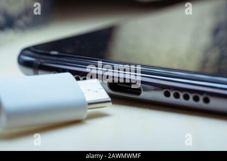 white USB Type C cable and USB-C port on smartphone Stock Photo