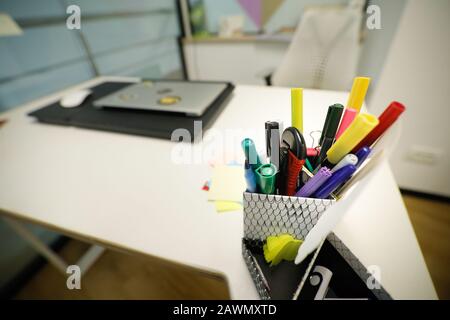 Shallow depth of field (selective focus) image with various pens, pencils and markers on an office desk. Stock Photo