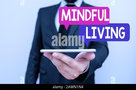 Writing note showing Mindful Living. Business concept for Having a sense of purpose and setting goals in life Male human wear formal work suit hold sm Stock Photo