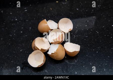 Eggshells from six eggs on a kitchen surface after being used for food preparation and cooking Stock Photo