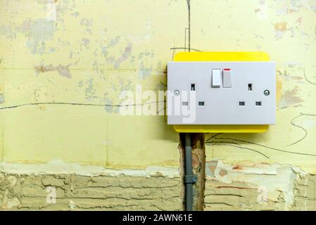 electric socket in a wall during renovation in england uk. Stock Photo