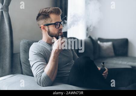 Vaping flavored e-liquid from an electronic cigarette Stock Photo