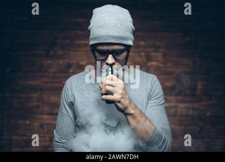 Vaping flavored e-liquid from an electronic cigarette Stock Photo
