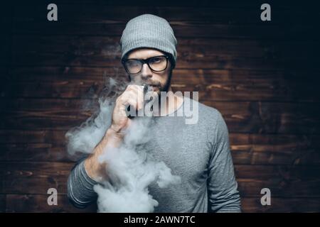 Vaping flavored e-liquid from an electronic cigarette Stock Photo