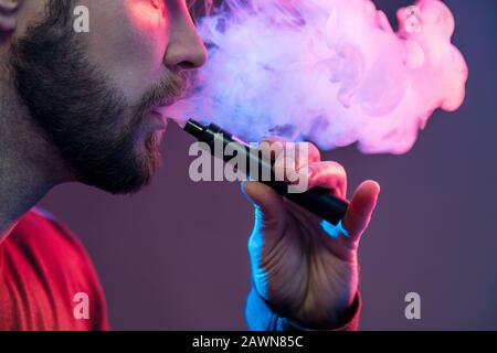Vaping flavored e-liquid from an electronic cigarette Stock Photo