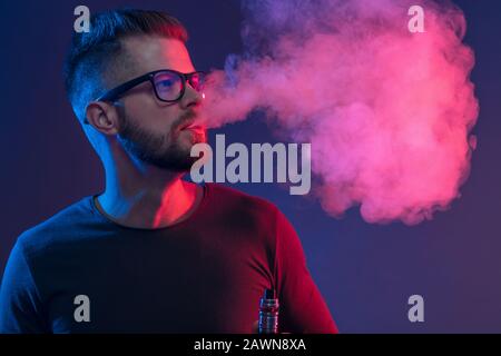 Vaping flavored e-liquid from an electronic cigarette Stock Photo