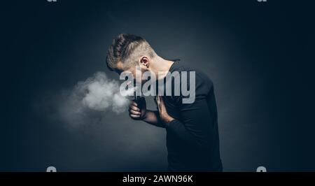 Vaping flavored e-liquid from an electronic cigarette Stock Photo