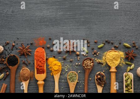 Various aromatic colorful spices and herbs in wooden spoons and scoops.  Ingredients for cooking.  Ayurvedic treatments. Top view. Stock Photo