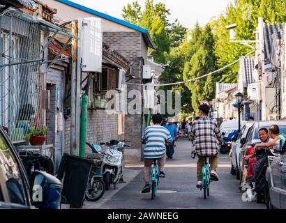 Cyclists in narrow street in Xi Cheng Hutong District, Beijing, China, Asia Stock Photo