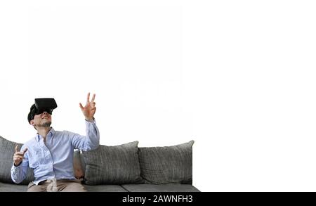Happily smiling man sitting on the sofa while experiencing virtual reality Stock Photo