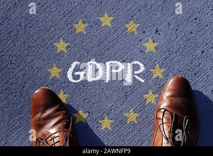 Man standing on the ground with the GDPR text written in the middle of the European flag Stock Photo