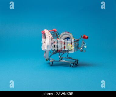 sewing accessories in the grocery basket, needles, threads, scissors, thimble on a blue background back Stock Photo