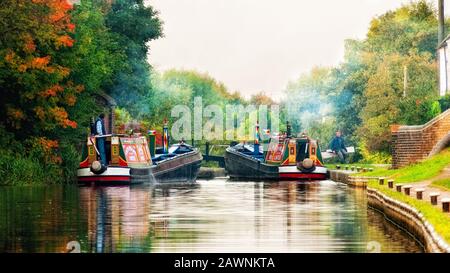Historic working boats entering a lock on the Coventry Canal near Tamworth, UK Stock Photo
