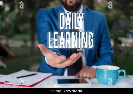 Word writing text Daily Learning. Business photo showcasing The everyday acquisition of knowledge or skills acquired Man with opened hands in fron of Stock Photo