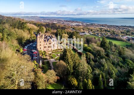 Belfast castle. Tourist attraction on the slopes of Cave Hill Country Park in Belfast, Northern Ireland. Aerial view. Belfast Lough and city in the ba Stock Photo