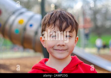 Portrait of a young, happy, smiling boy in a children's playground. Stock Photo