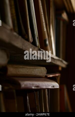 An old shelf with shabby rows of books. Stock Photo
