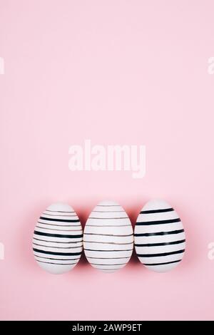 Many easter eggs on trendy pink pastel background. Eggs are hand-drawn. Flat lay style. Stock Photo