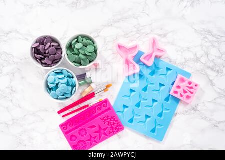 Flat lay. Ingredients to make chocolate mermaid molds from the chocolate chips. Stock Photo