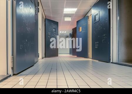 Low angle shot of rooms with doors wide open along a tiled hallway Stock Photo