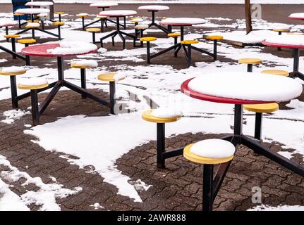 Metal picnic tables covered in melting snow in winter in Pittsburgh, Pennsylvania, USA Stock Photo