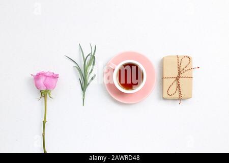 Pink purple rose flower and black tea, gift box on white background. flat lay, top view, copy space Stock Photo