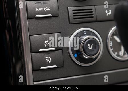 The button for the stability control system, side mirrors adjust and headlight washer on black panel of car near the steering wheel to overcome off-ro Stock Photo