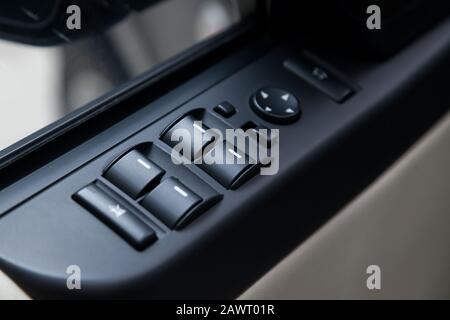 The control buttons for opening and closing windows of doors and electric controls and settings of locks on the door in black with plastic upholstery Stock Photo